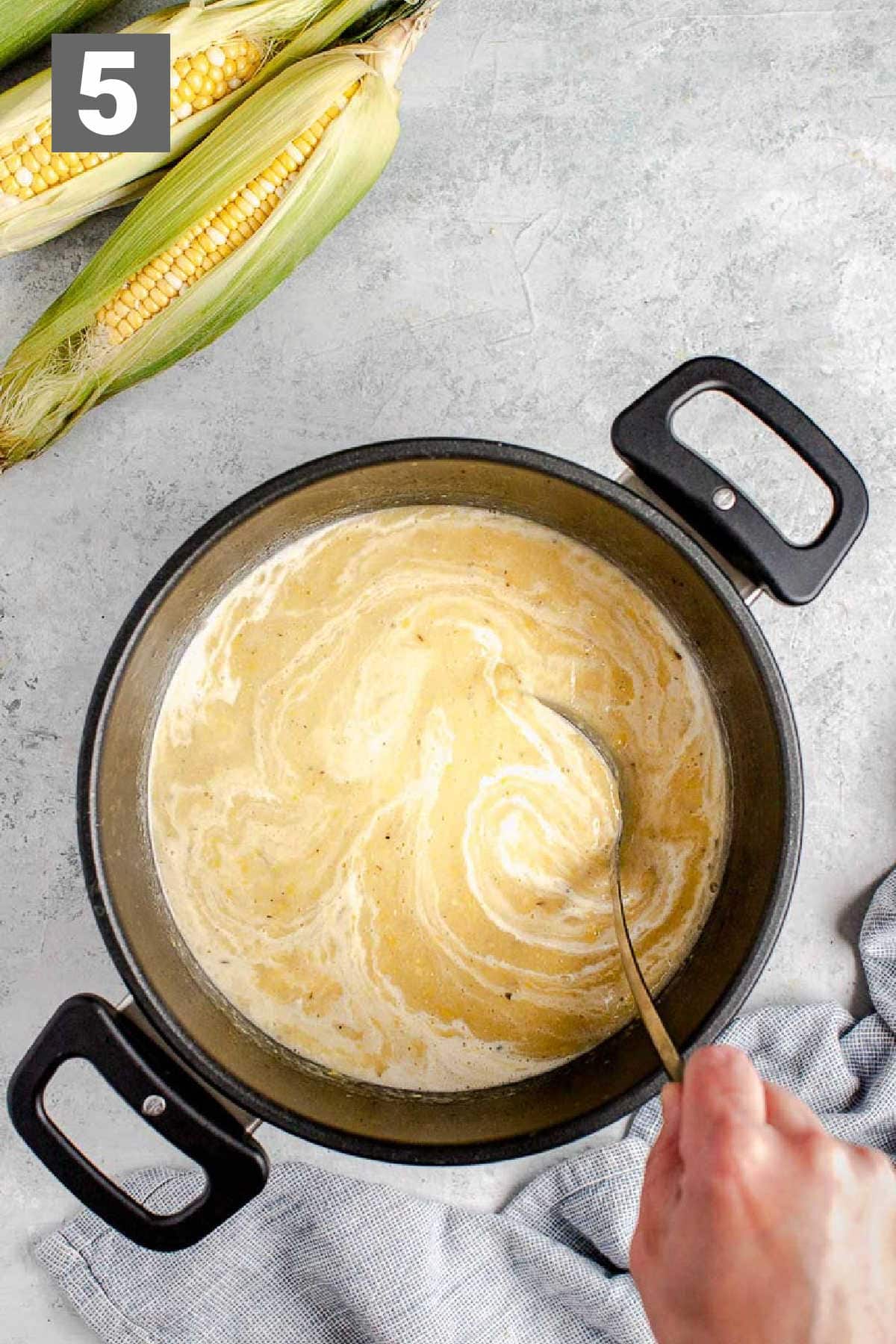Stirring the heavy cream into the chowder