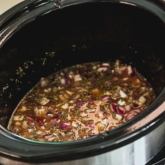 Broth, garlic, red onion, lime juice, spices and chipotle in a slow cooker.
