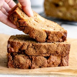 stack of apple bread slices and a hand taking the top slice