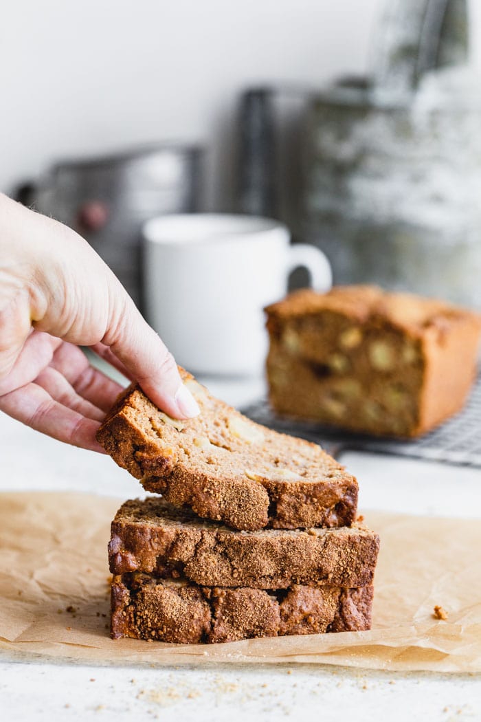 Apple Bread stacked and a hand taking the top slice off
