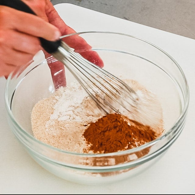 3. Whisk all-purpose flour, whole-wheat flour, baking powder, baking soda, salt and the remaining 2 teaspoons cinnamon in another bowl