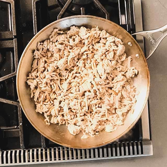 Ground turkey cooking in a large skillet
