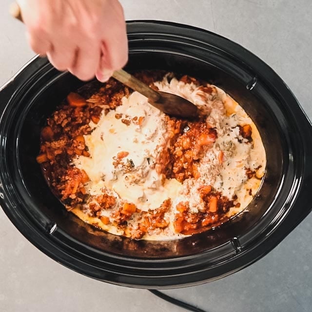 Stirring half and half into bolognese in a slow cooker
