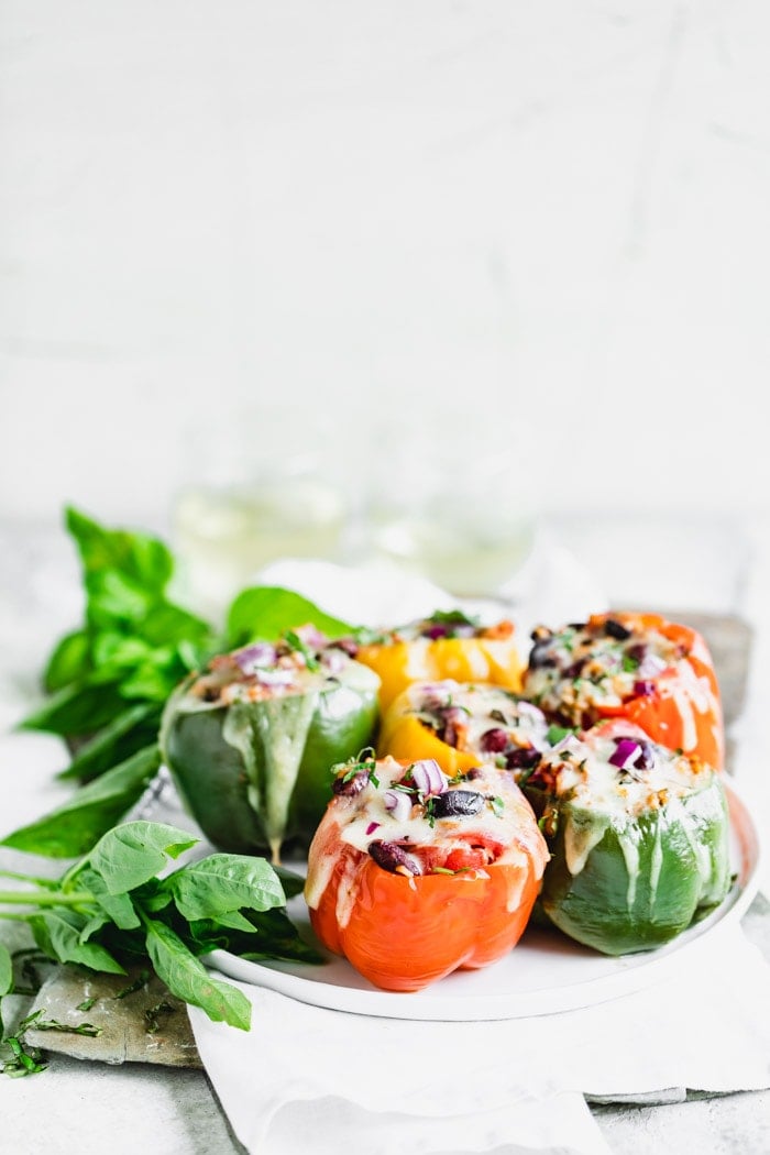 a plate of peppers from the side on a white table
