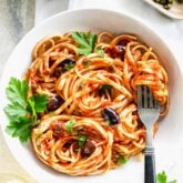 Pasta in a shallow white bowl with a fork in it