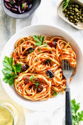 Pasta in a shallow white bowl with a fork in it