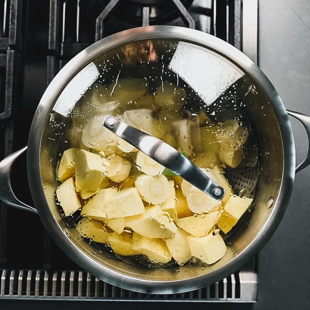 a pot with steaming root vegetables