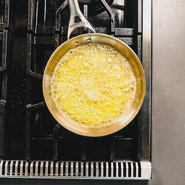 Sizzle the garlic in the melted butter and olive oil until it is just starting to brown