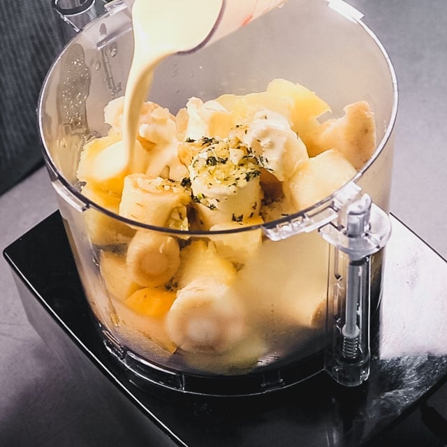 half the ingredients are in a food processor before pureeing