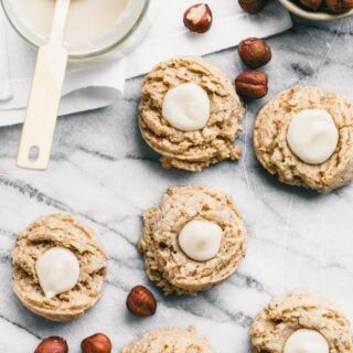 work surface with cookies, hazelnuts and maple cream