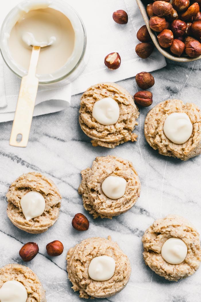 work surface with cookies, hazelnuts and maple cream