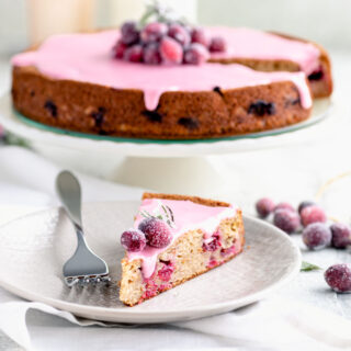 cranberry cake from the side and a slice on the plate