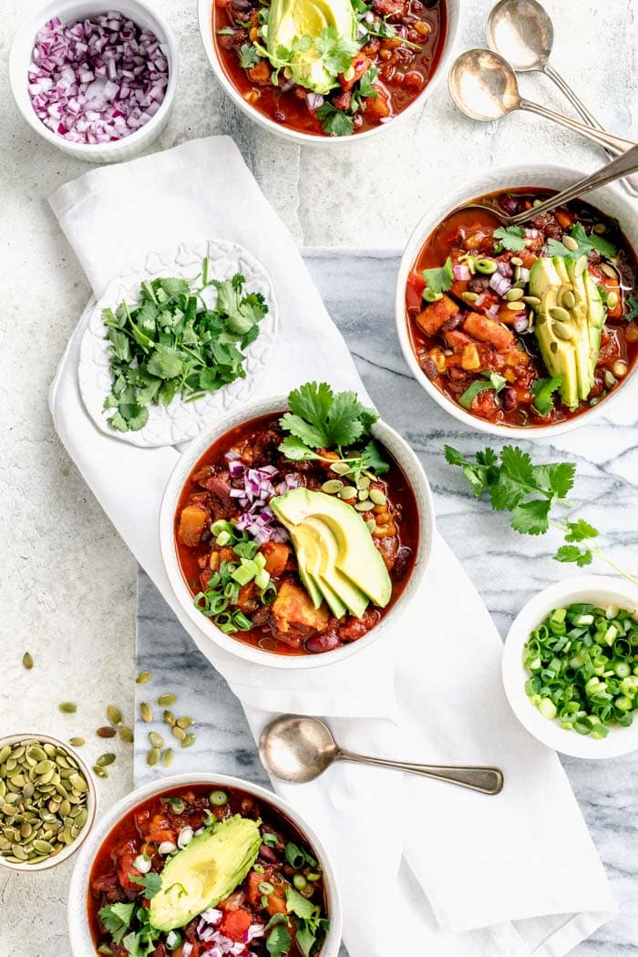 bowls of chili with colorful toppings