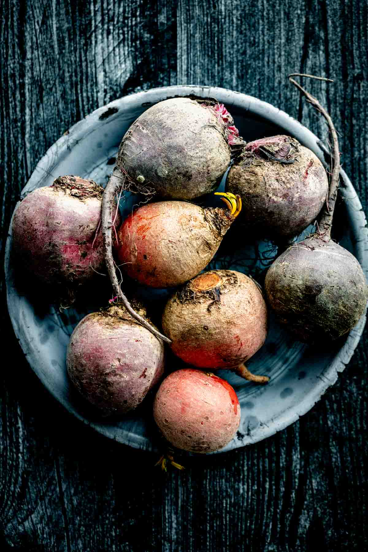 a large bowl of multicolored beets, including gold, red and purple