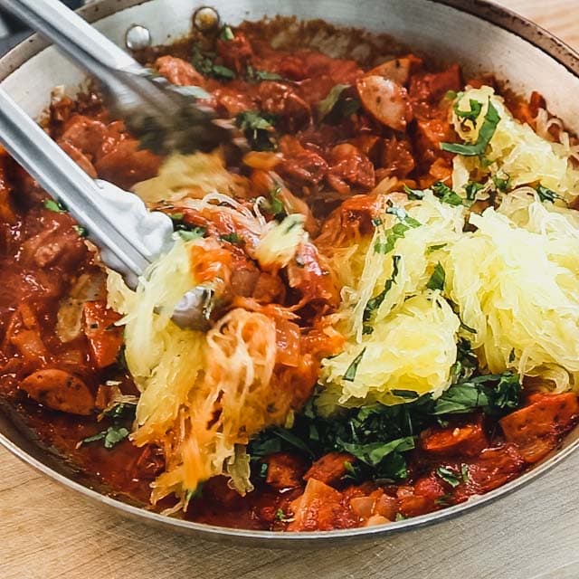 stirring the spaghetti squash and basil into the chicken sausage and marinara