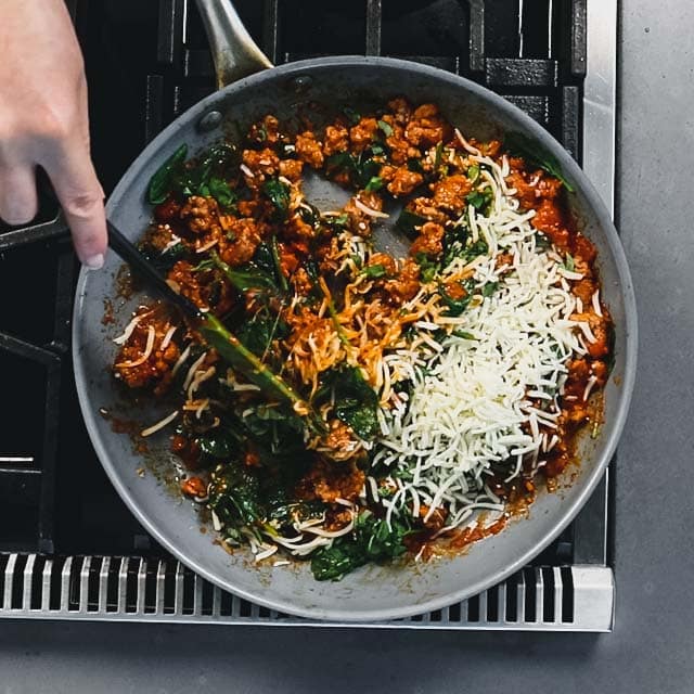 add the basil and 3/4 cup cheese and stir to combine
