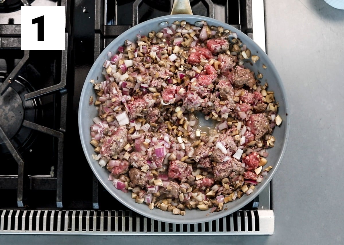 the ground beef with mushrooms and onions cooking in a skillet