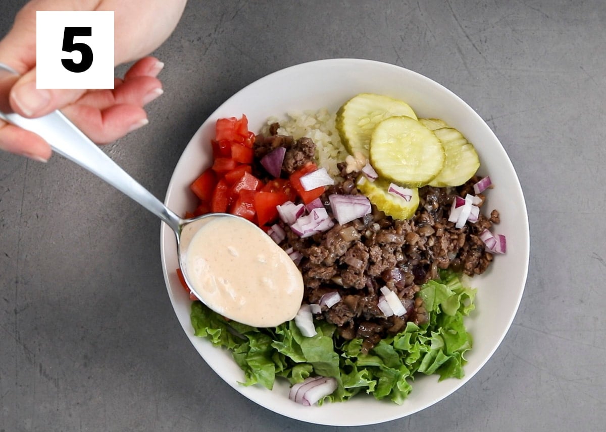 spooning the special sauce over the hamburger bowl