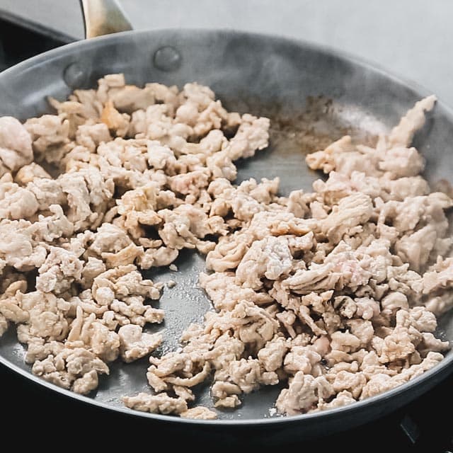 the browned ground chicken in the non-stick skillet
