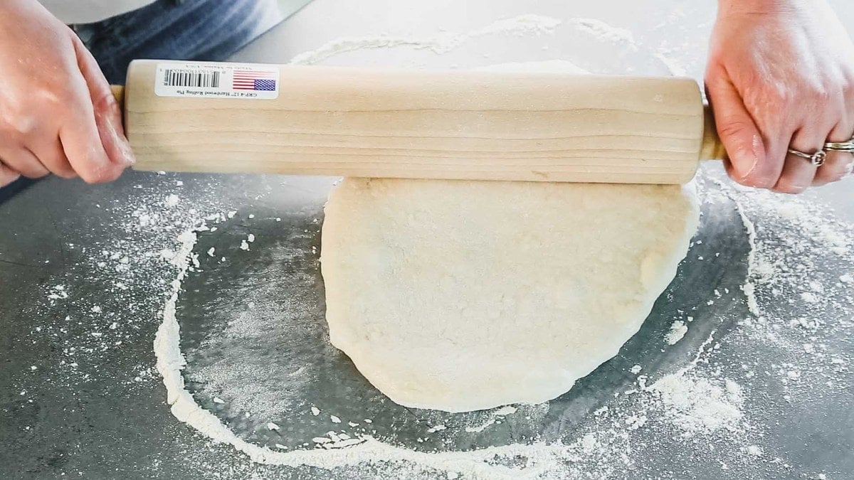 rolling pizza dough with a rolling pin