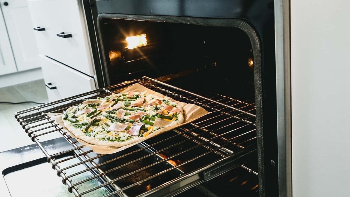 the pizza on the parchment on the oven rack
