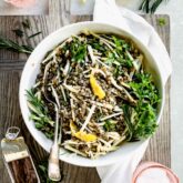 lentil and celery root salad with herbs in a bowl from overhead with pink water glasses