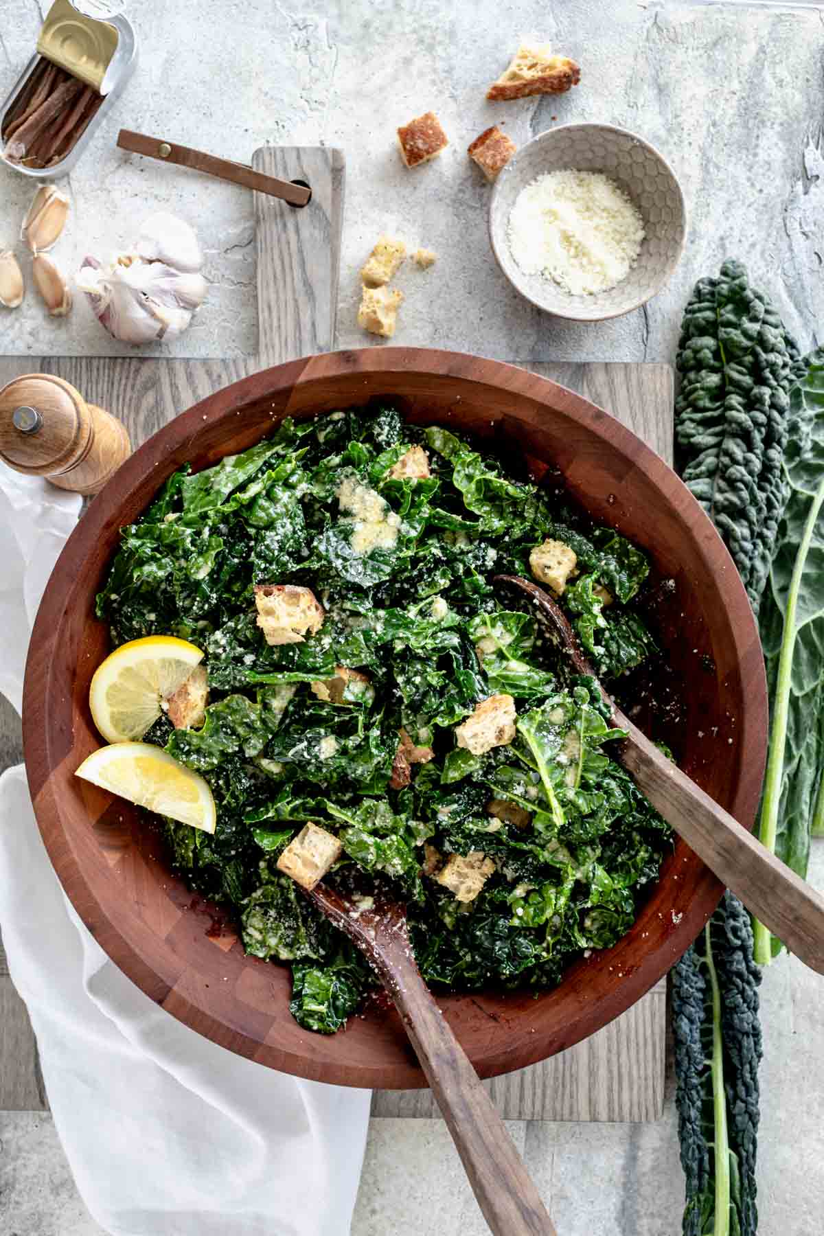 tuscan kale salad in a wooden bowl with salad spoons