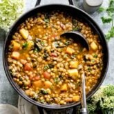 black pot overhead with soup with a ladle