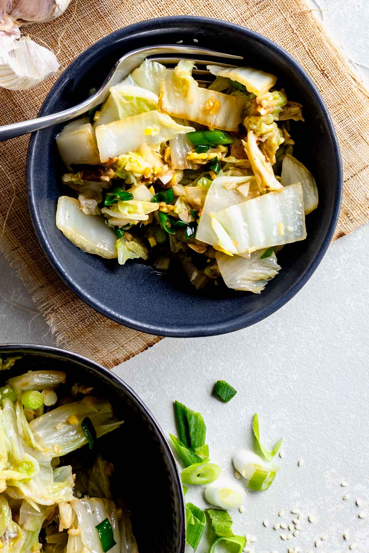 black bowls with stir-fried Napa cabbage in them