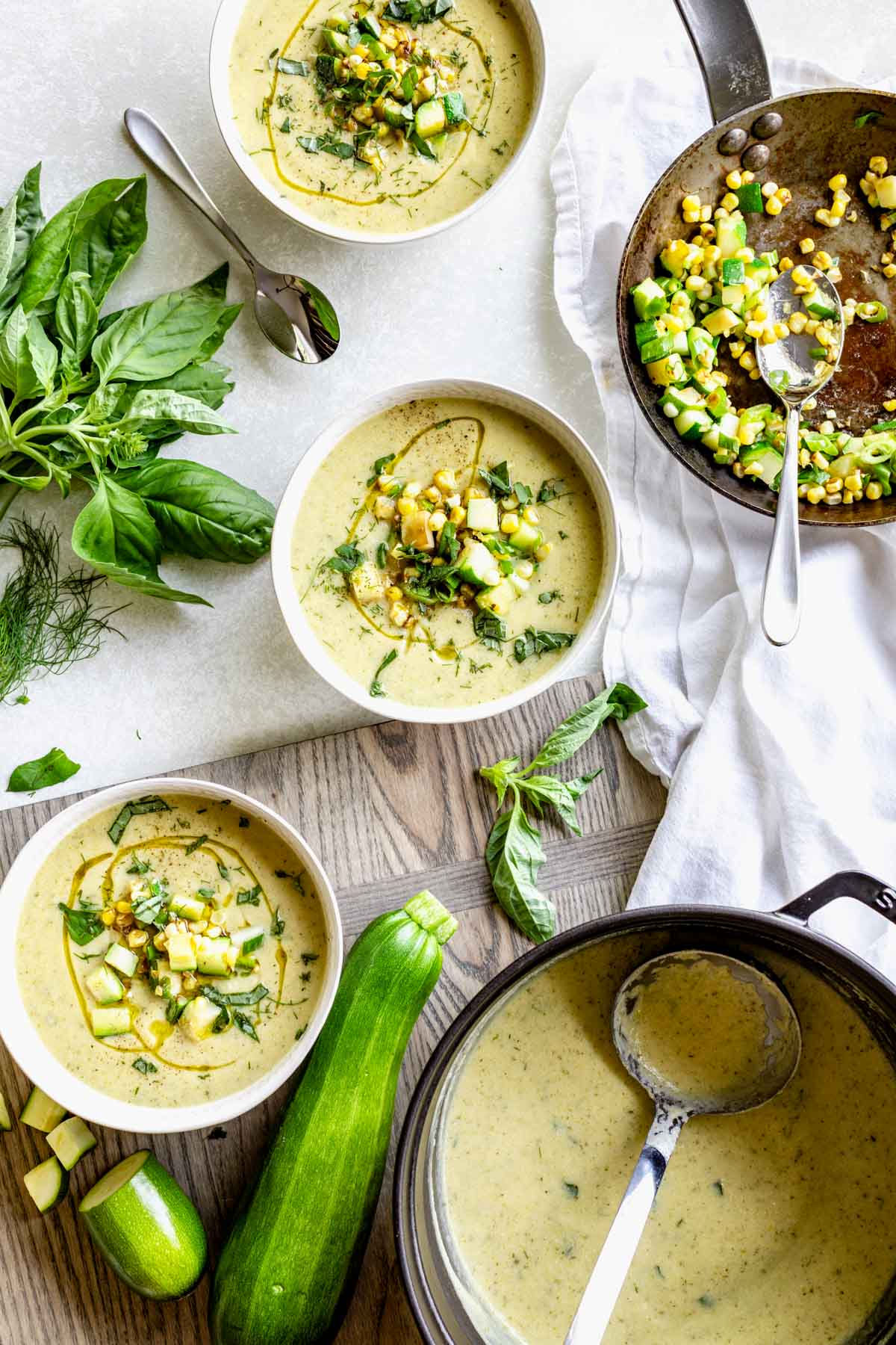 bowls of soup topped with corn and zucchini mixture a pot of the pureed soup with ladle
