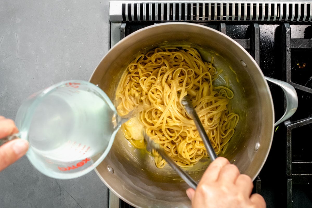 thinning the sauce with the pasta liquid