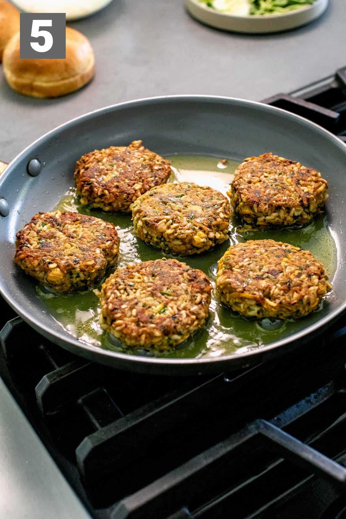 cooking the burgers in the skillet