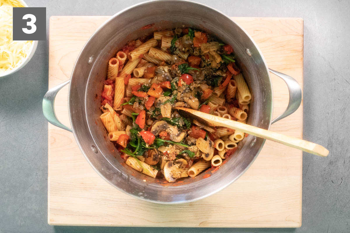 combining the pasta and veggies in the pasta pot