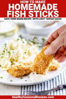 fish sticks on a white plate with someone dunking one into tartar