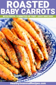 WHOLE BABY CARROTS ROASTED AND MIXED WITH PESTO IN A BLUE BOWL