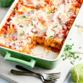 the squash lasagna in a green casserole dish on a white cutting board