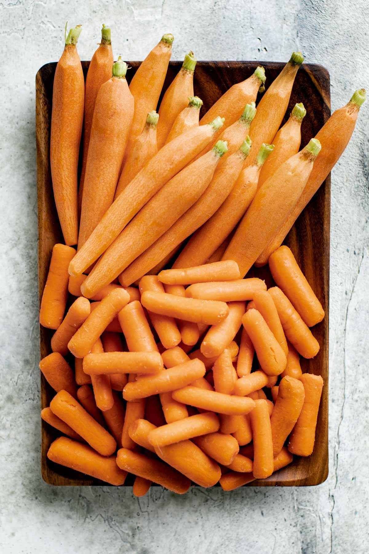 a plate with baby carrots and baby cut carrots on it