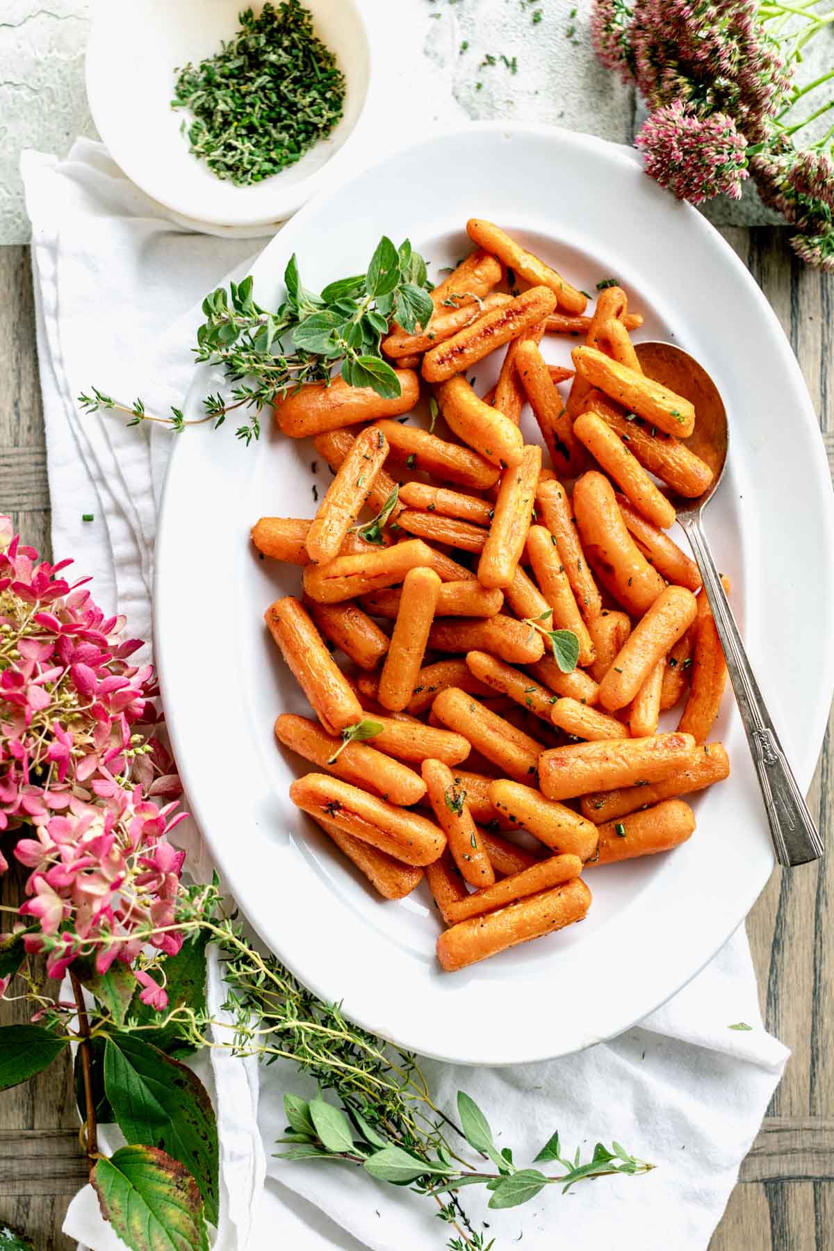 an oval platter with roasted baby carrots on it