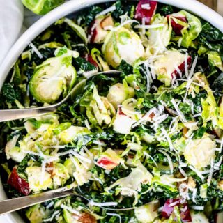 Close-Up of shaved Brussels sprouts and kale salad in white circular bowl.