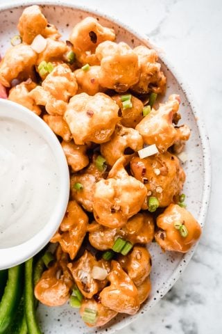 white platter of bang bang cauliflower with dip