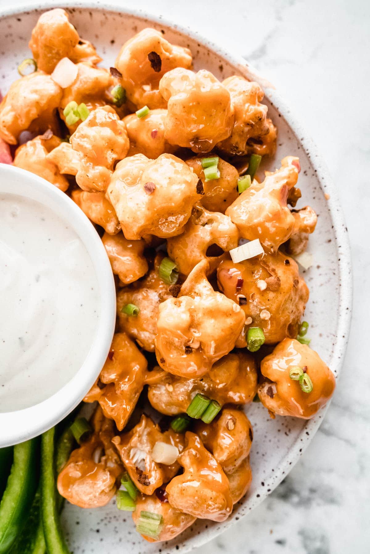 white platter of bang bang cauliflower with dip