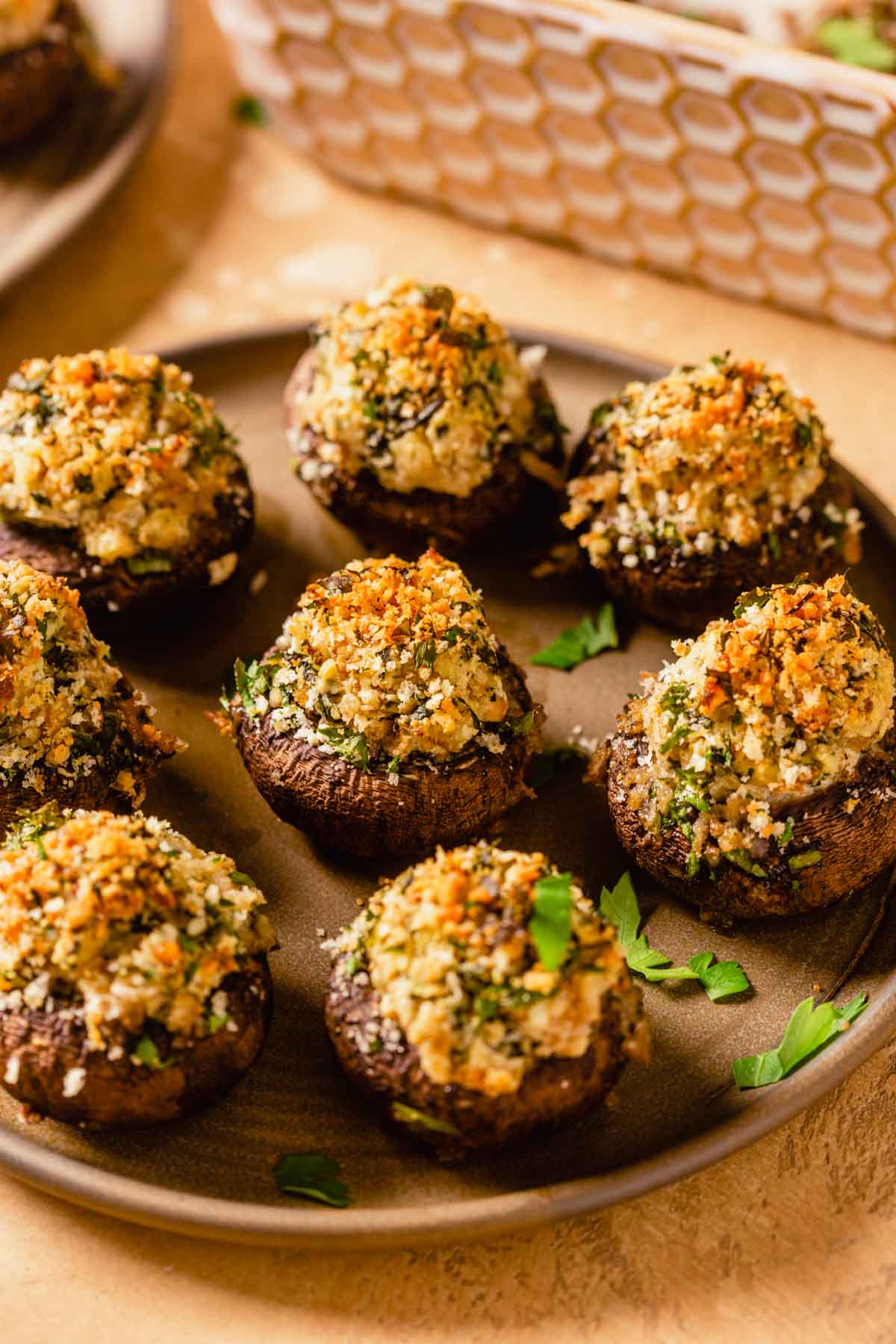 stuffed mushrooms topped with breadcrumbs on a brown plate