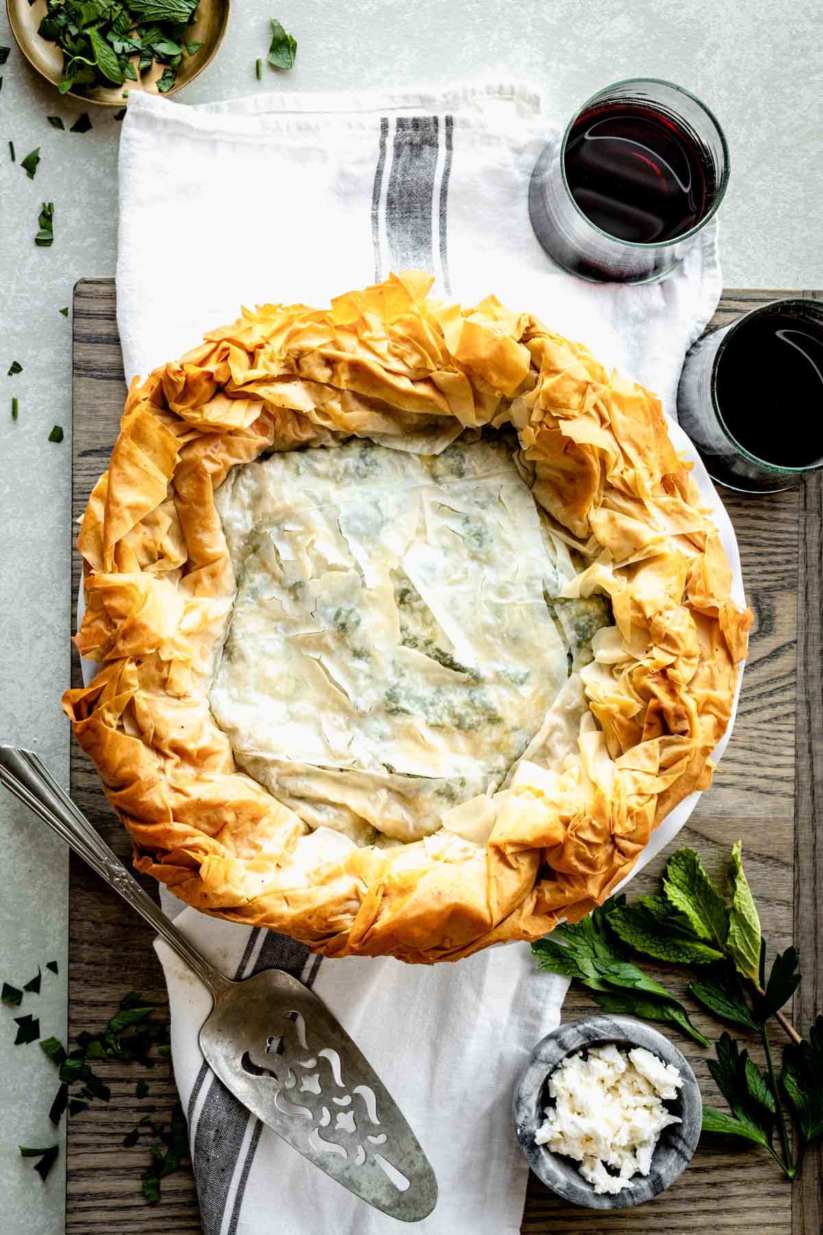 Finished Spinach Feta Filo Pie in circular casserole dish with serving spatula