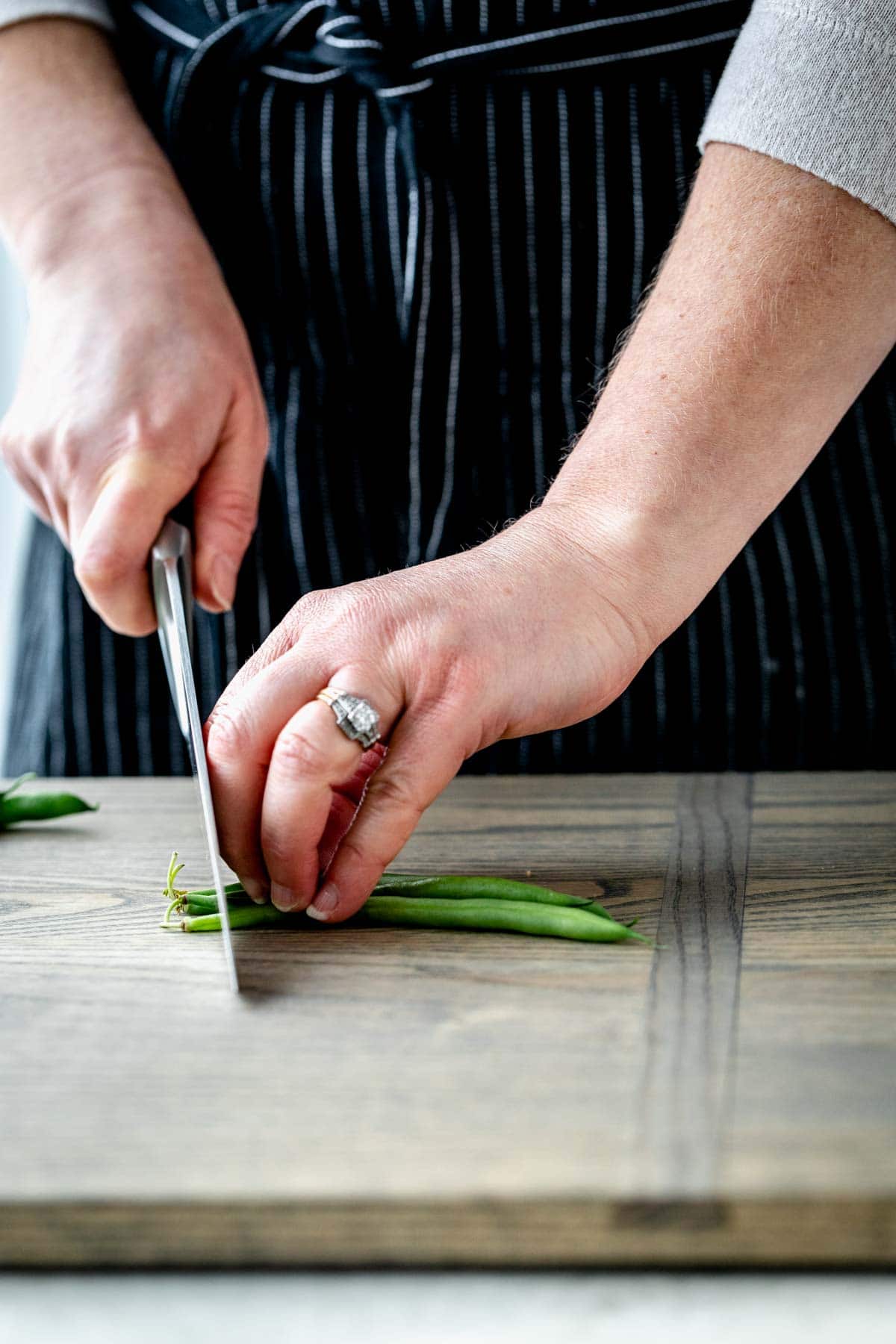 trimming several green beans at a time with a knife