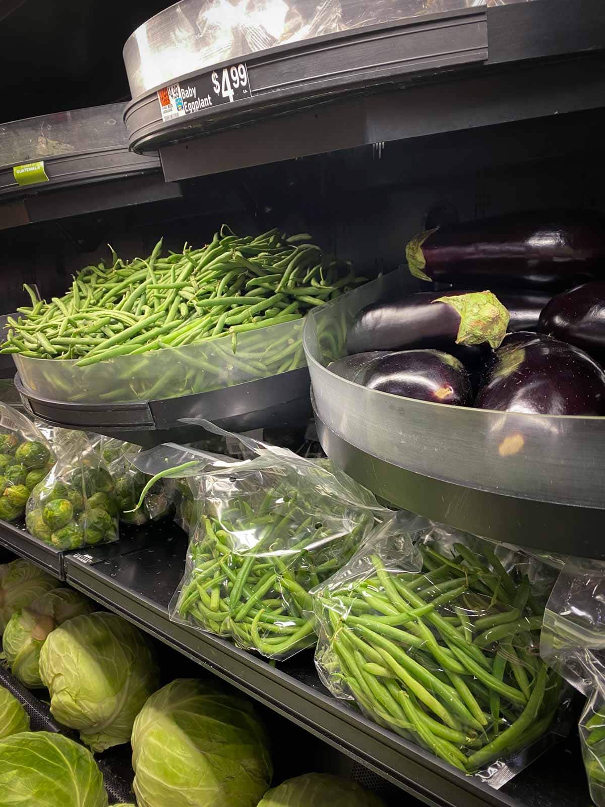 green beans for sale in a supermarket in both a bulk bin and in pre-portioned bags