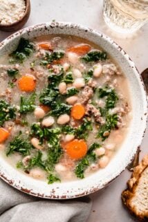 Sausage Kale soup with carrots and white beans in bowl