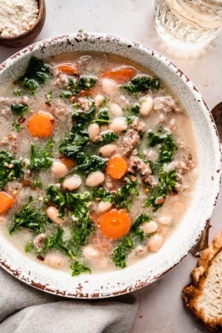 Sausage Kale soup with carrots and white beans in bowl