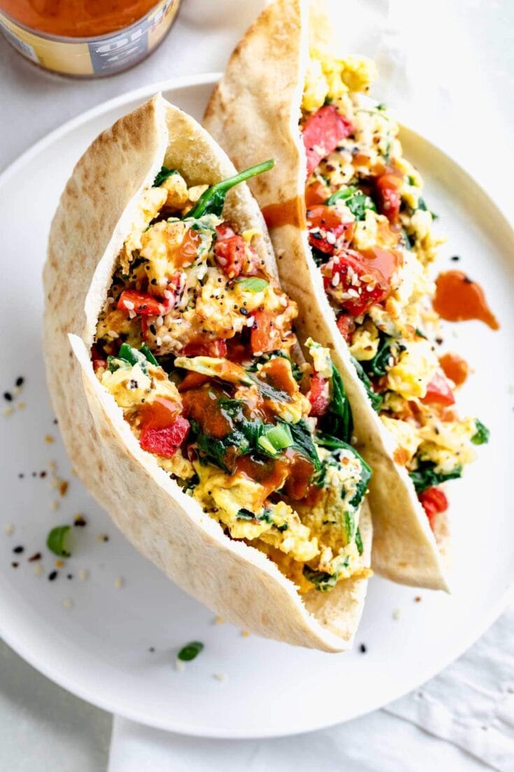 Breakfast pita on circular white plate showing egg mixture
