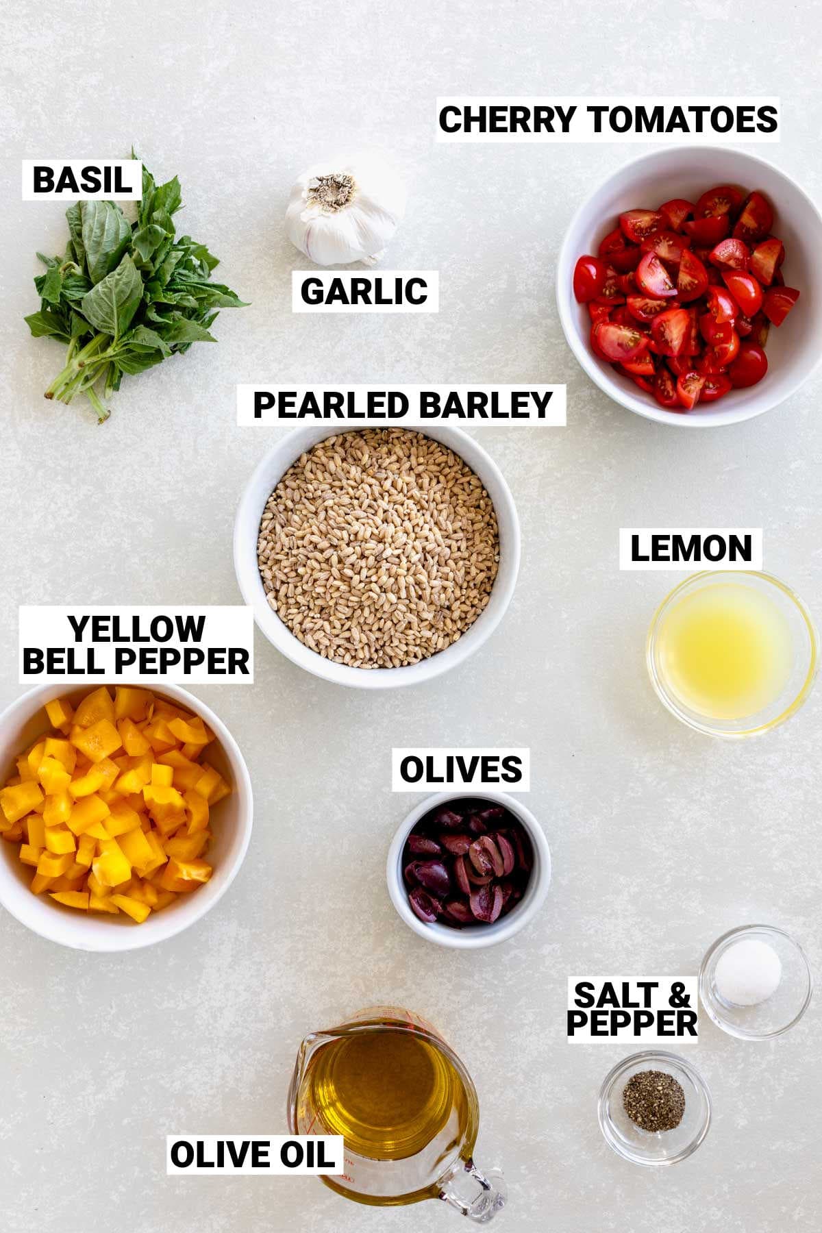 ingredients for mediterranean barley salad on white counter with text overlay.
