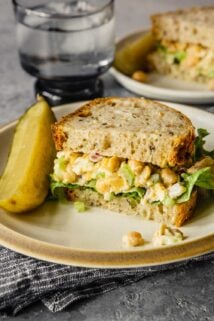 chickpea tuna salad on a white plate with a pickle spear